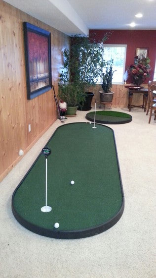 small indoor putting green next to chipping pad